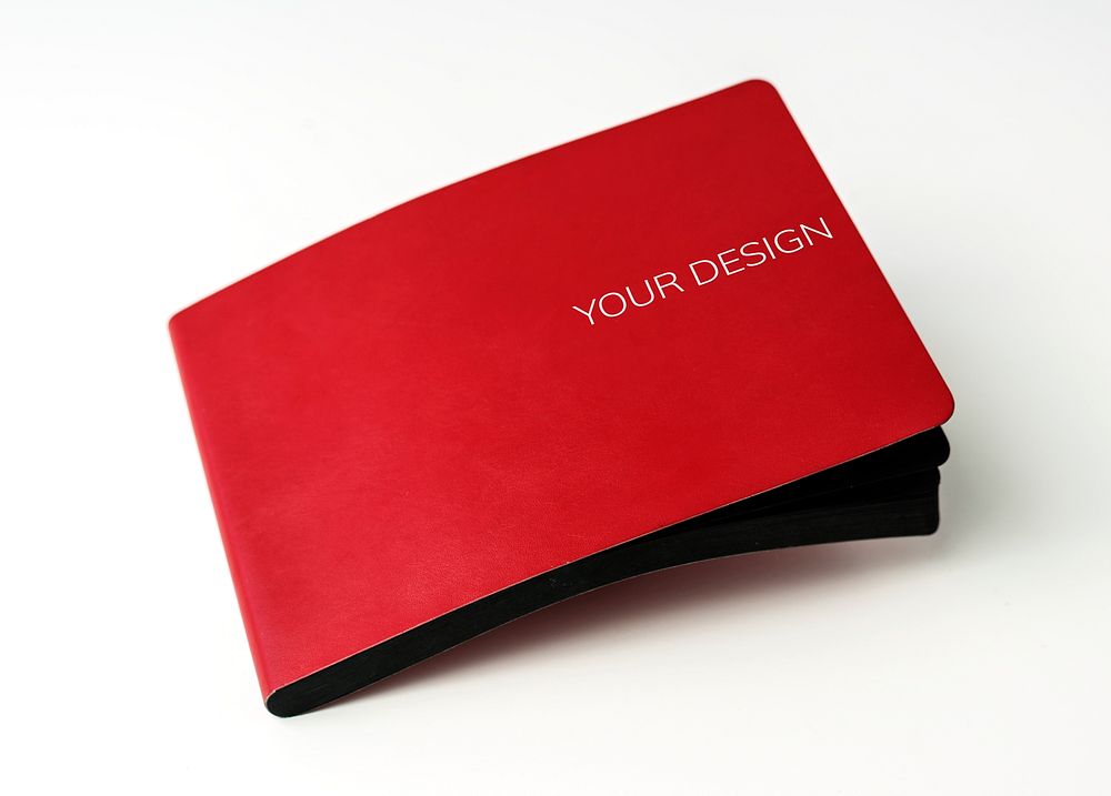 Closeup of red cover notebook on white table