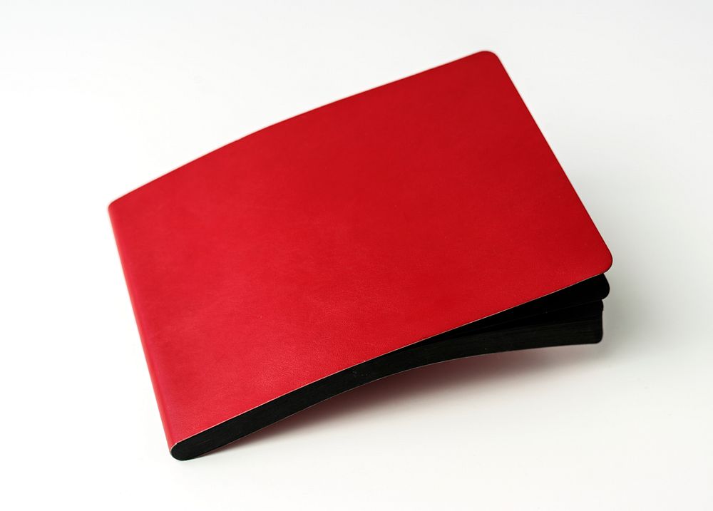Closeup of red cover notebook on white table