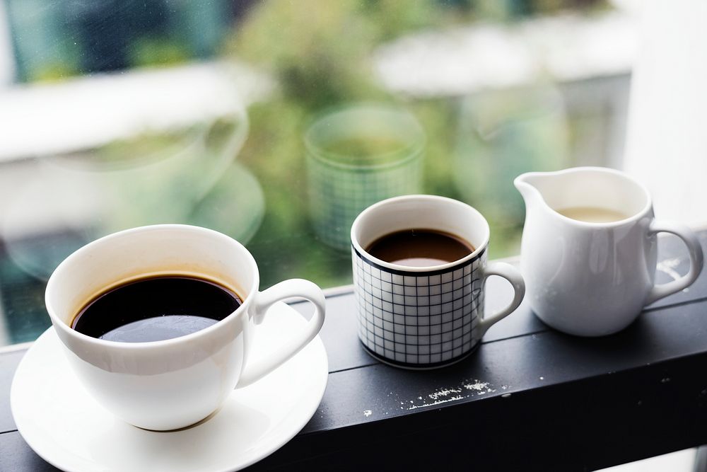 Three coffee cups by the window