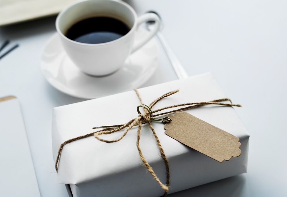 Closeup of gift box with empty label tag and coffee cup