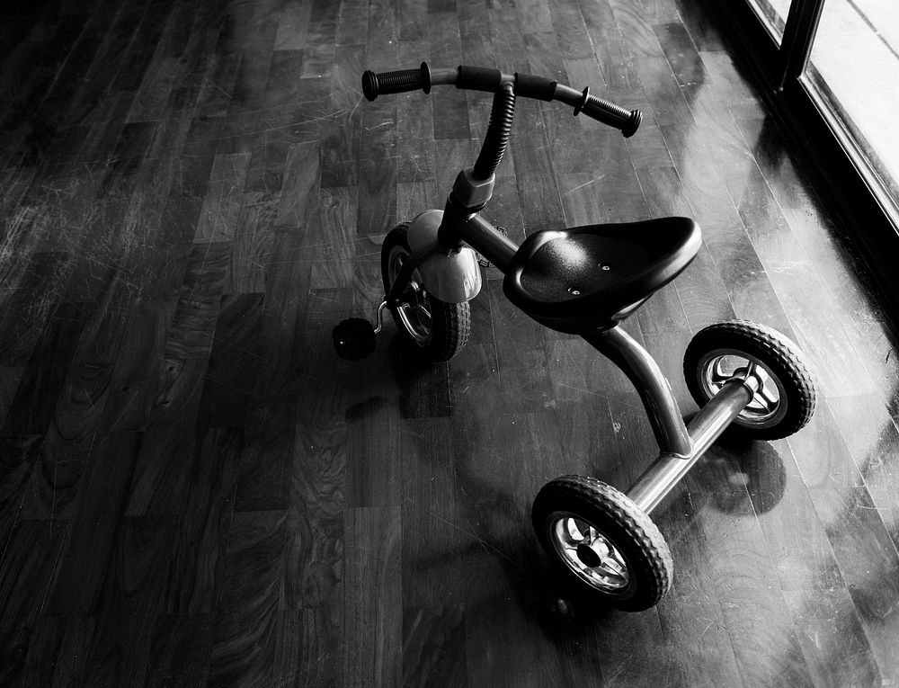 Kid bicycle on the wooden floor grayscale