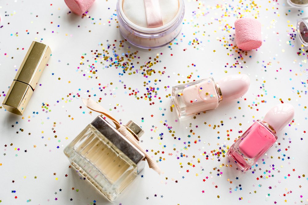 Cosmetic objects and confetti isolated on background
