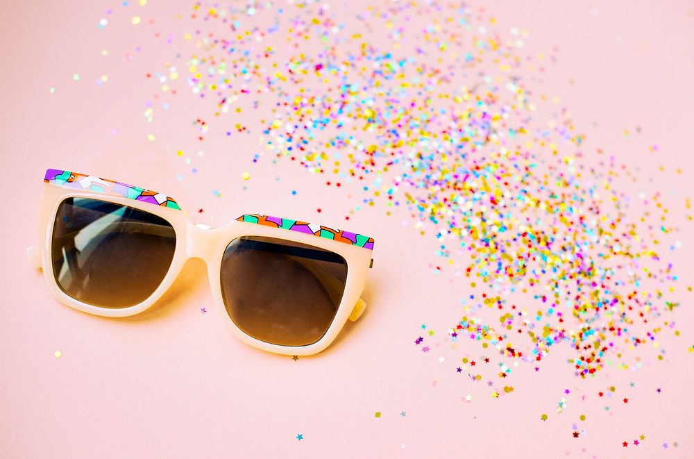 Sunglasses and confetti isolated on background