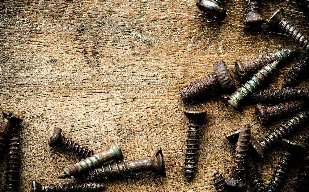Aerial view of rustic screws on wooden plank macro
