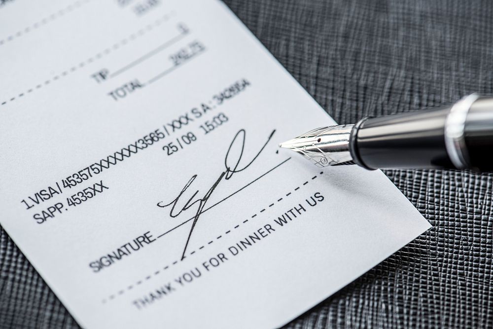 Macro of signing fountain pen on receipt