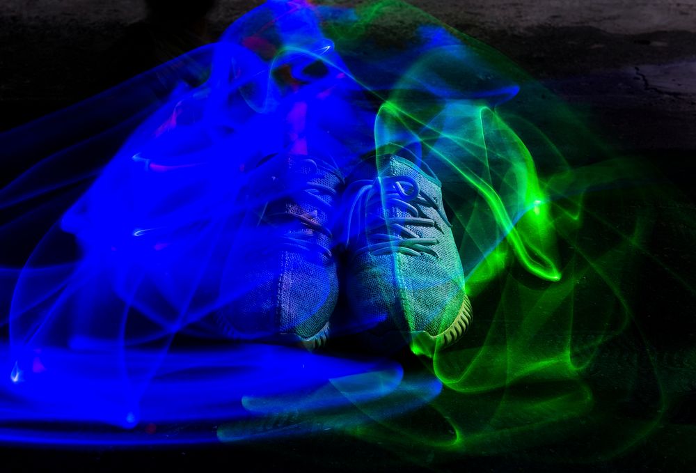 Long exposure blue and green light lines movement over sneakers