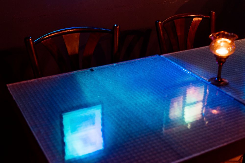 Reflection of blue light on dining table glass in the restaurant