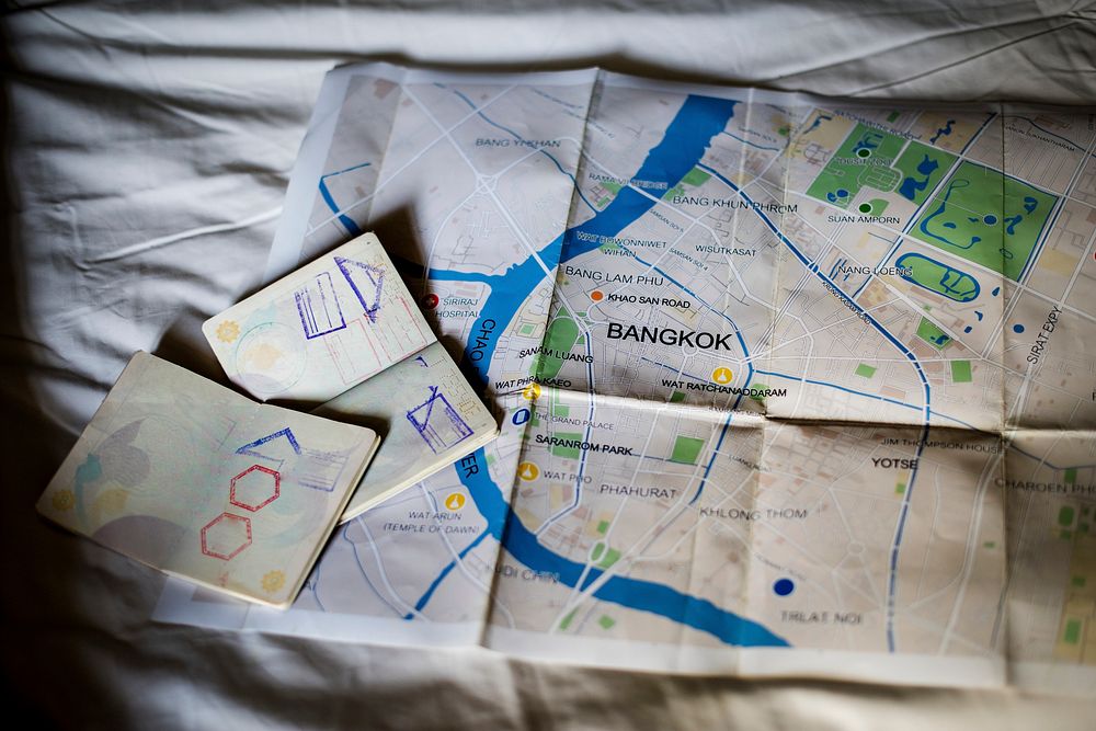 Closeup of open passports with Bangkok, Thailand map
