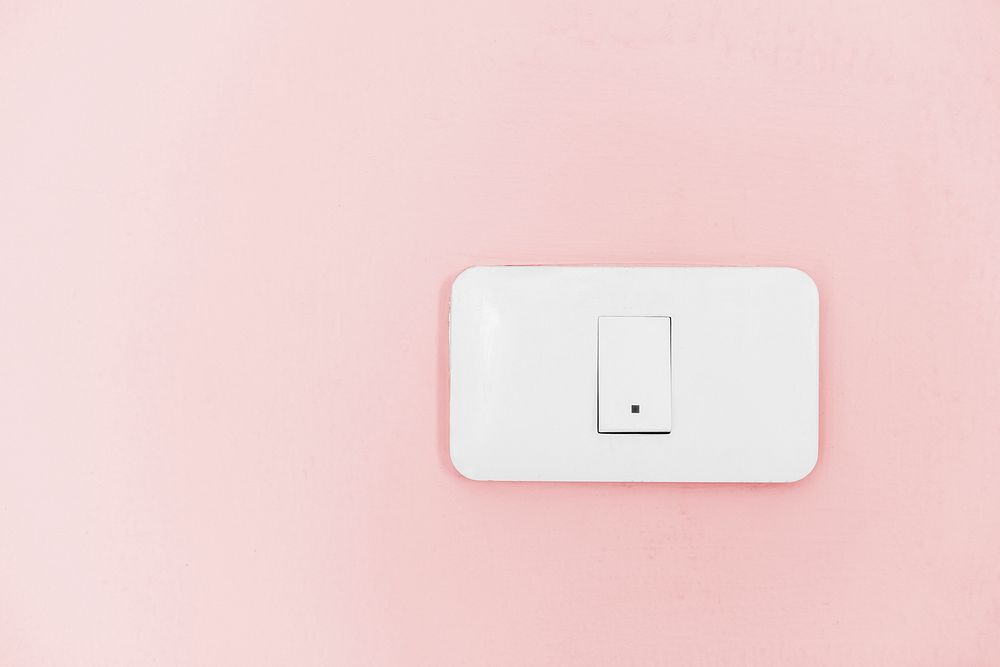 White light switch electric power supply on pink wall
