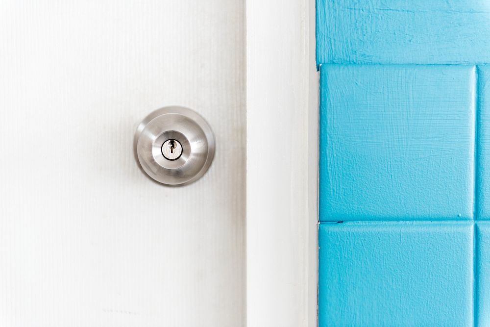 Closeup of stainless steel door knob on white door