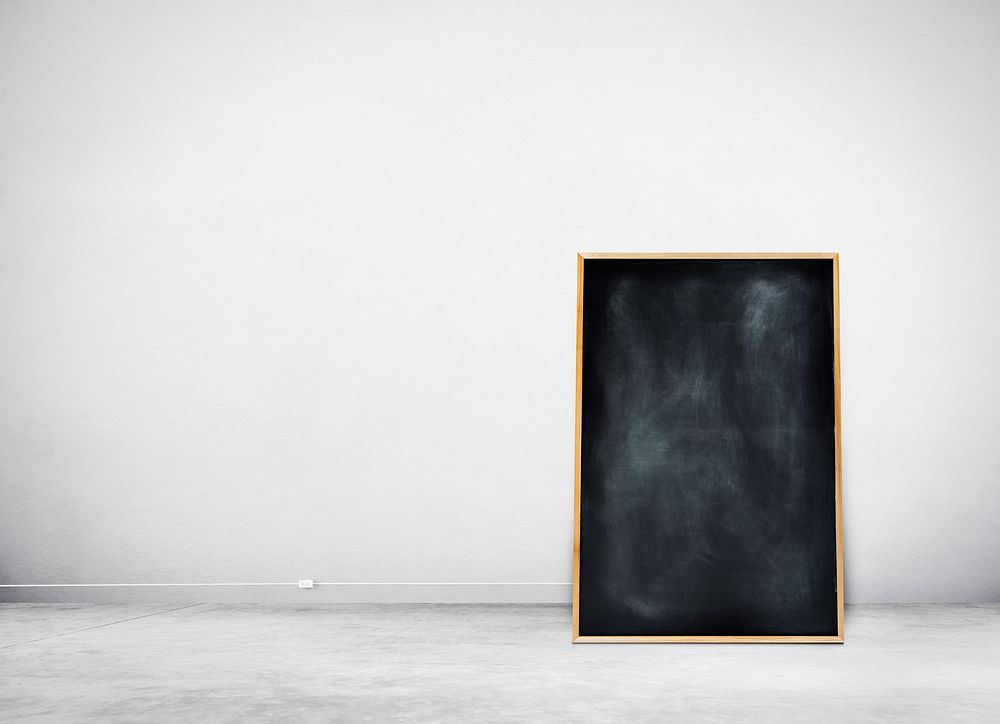 Blank Black Chalkboard on a White Wall