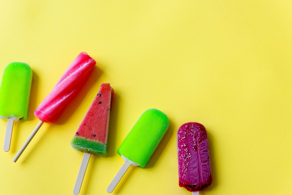 Closeup aerial view of colorful ice cream on yellow background
