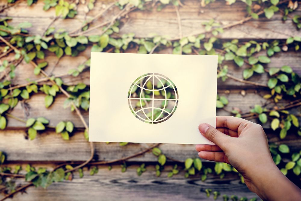 Hand Hold Globe Paper Carving with Wooden Background