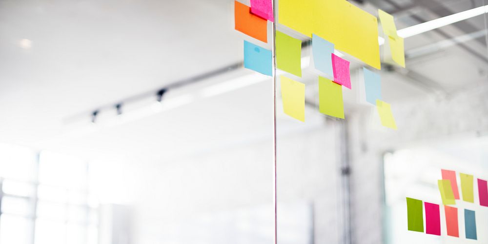 Closeup of colorful blank sticky notes on office glass