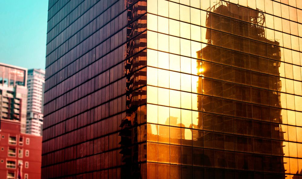 Reflection of metro city buildings on glass mirror exterior