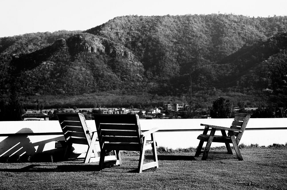 Empty Chairs on Grass Field Among Mountains Nature