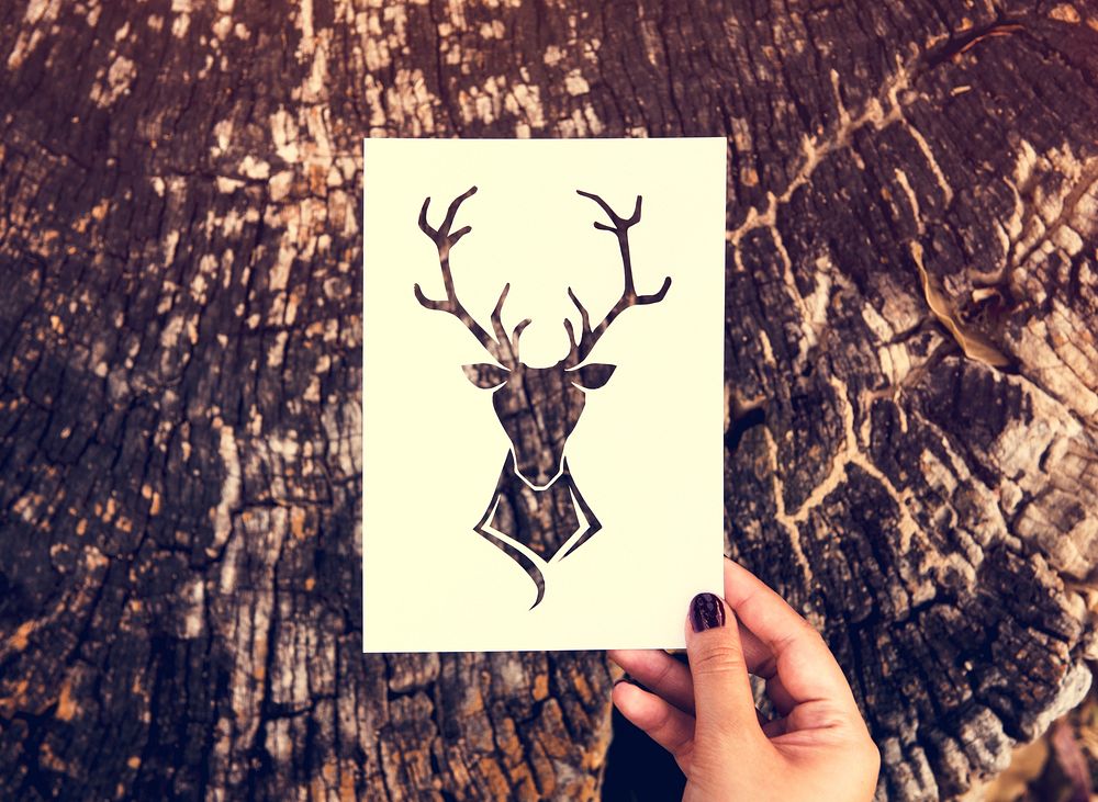 Hand Hold Deer with Antlers Paper Carving with Nature Background