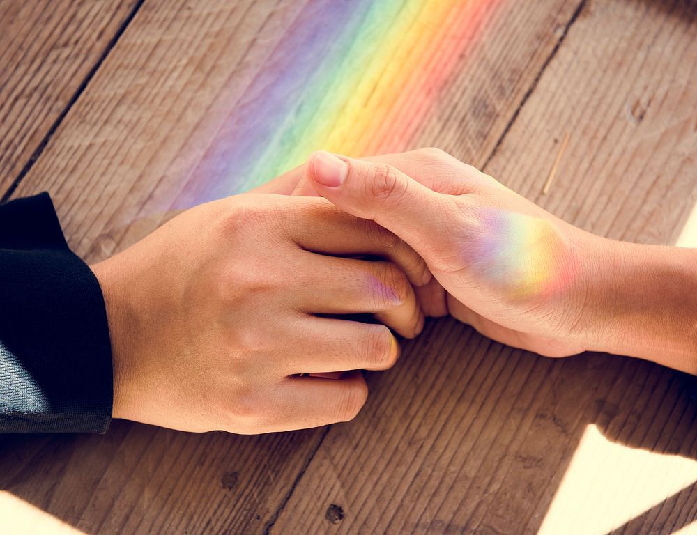 Rainbow reflect on hands holding together