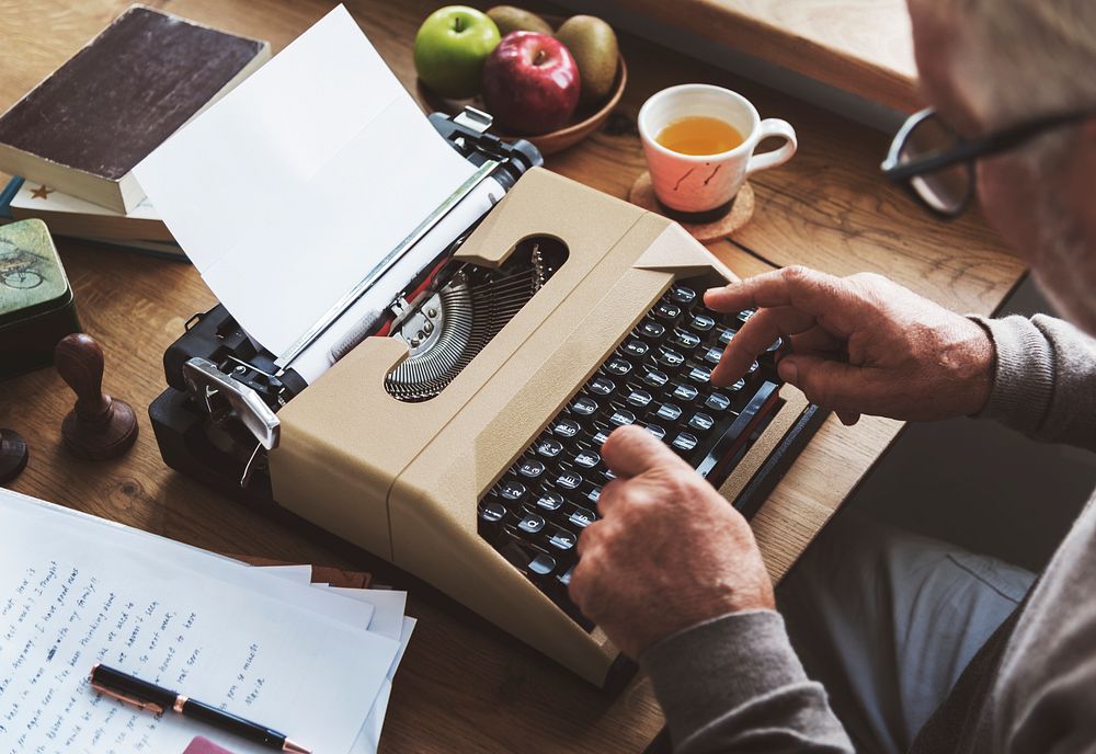 Old man typing on a typewriter