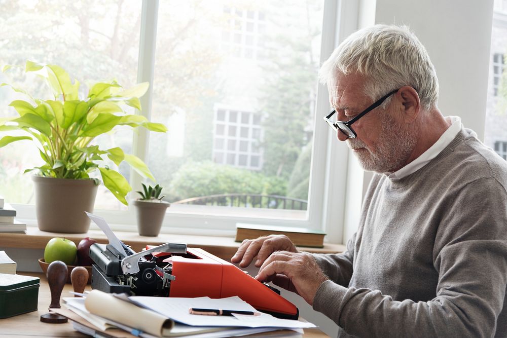 Old man typing on a typewriter