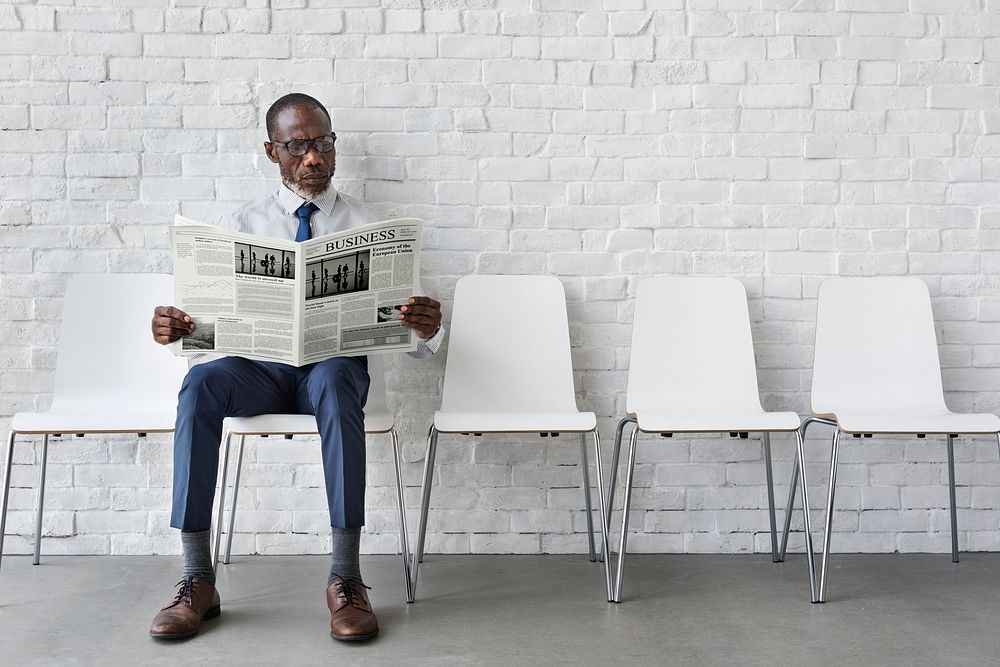 African Businessman Reading Newspaper Workplace Concept