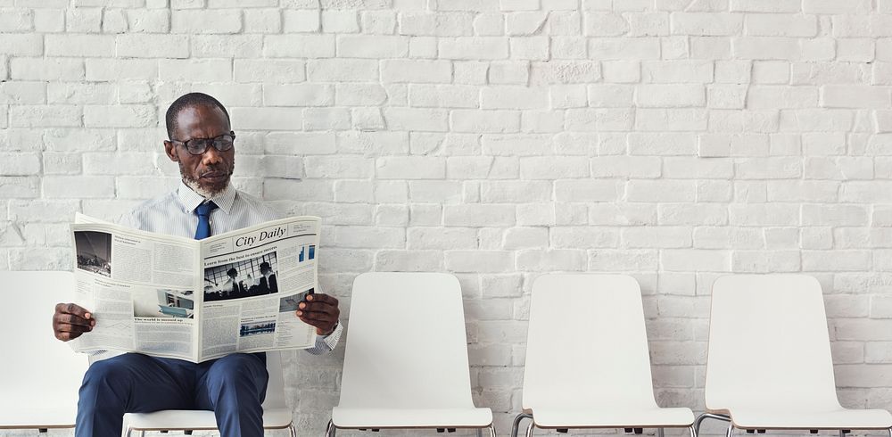 African Businessman Reading Newspaper Workplace Concept