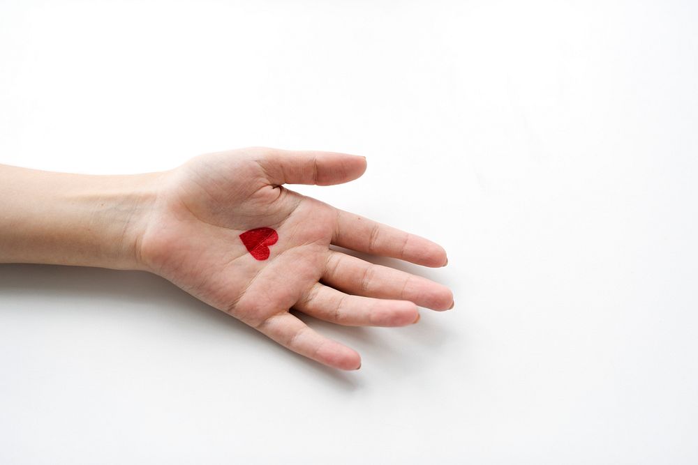 Aerial view of heart drawing on hand on white background