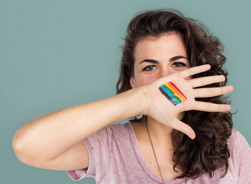 Portrait of a woman showing a pride flag on her palm
