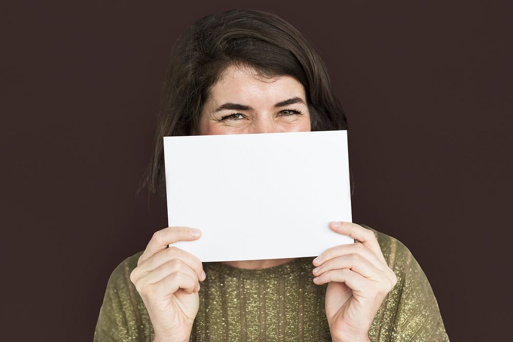 Woman holding a blank piece of paper to her nose and mouth