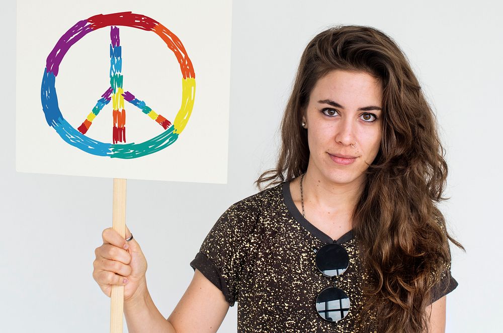 Woman holding placard with LGBT peace icon