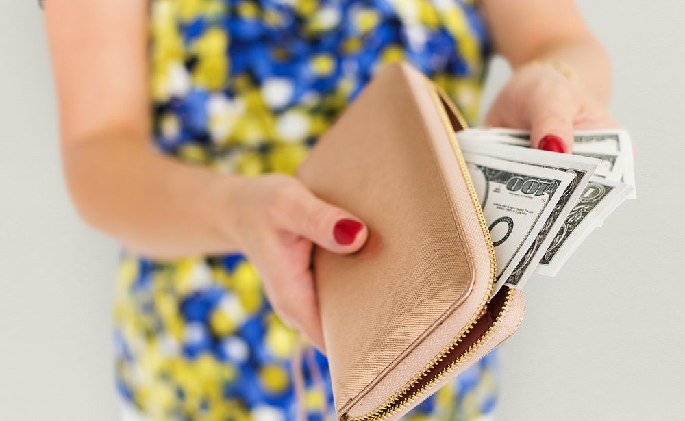 Close up of woman's hands taking money out of the purse