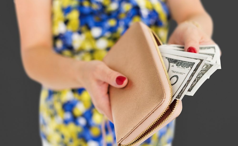 Close up of woman's hands taking money out of the purse