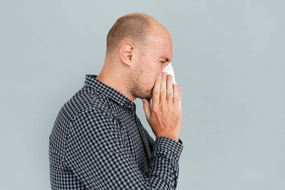 Man sneezing blowing nose sickness