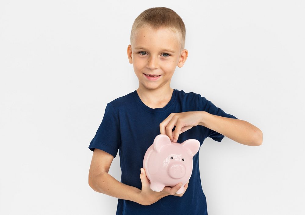 Blond boy saving his money in a piggy bank