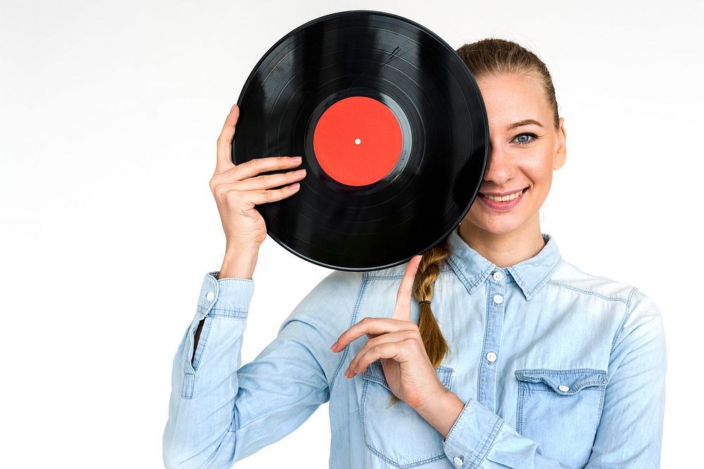 Studio portrait of a vinyl record to half her face