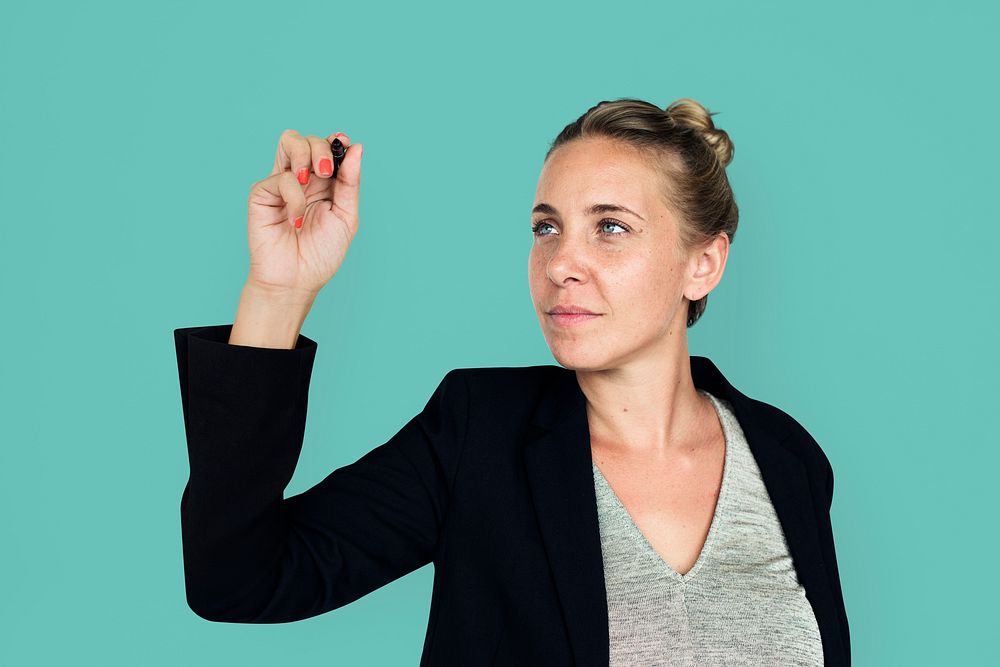 Studio portrait of a business woman writing on air with a pen