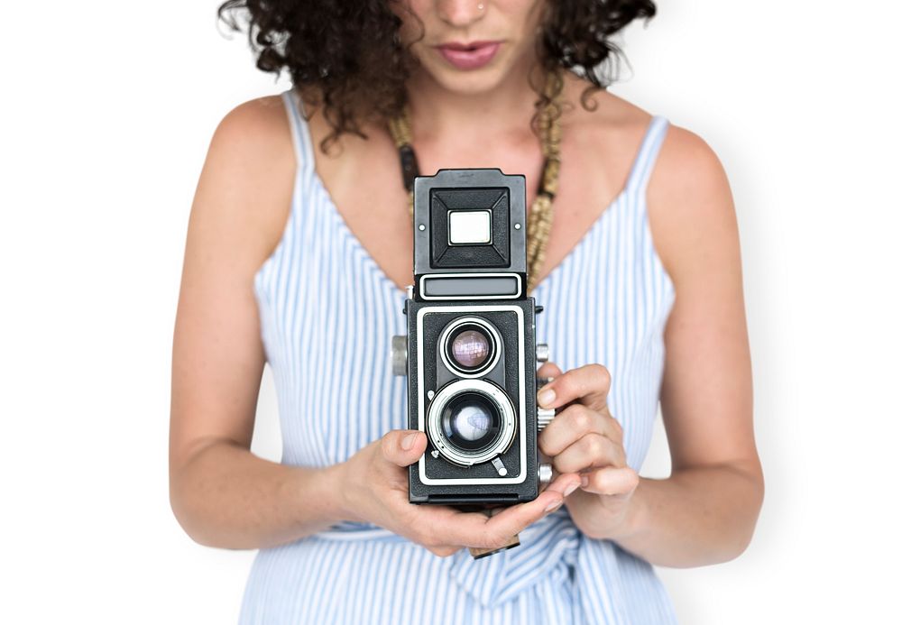 Studio portrait of a woman holding an old school camera