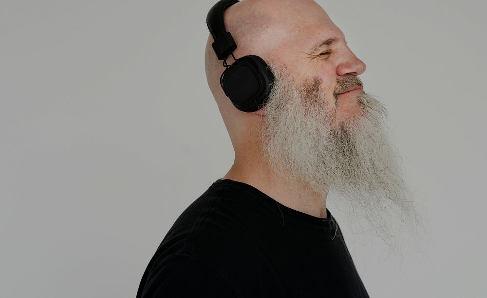 Portrait of a big bearded man listening to music