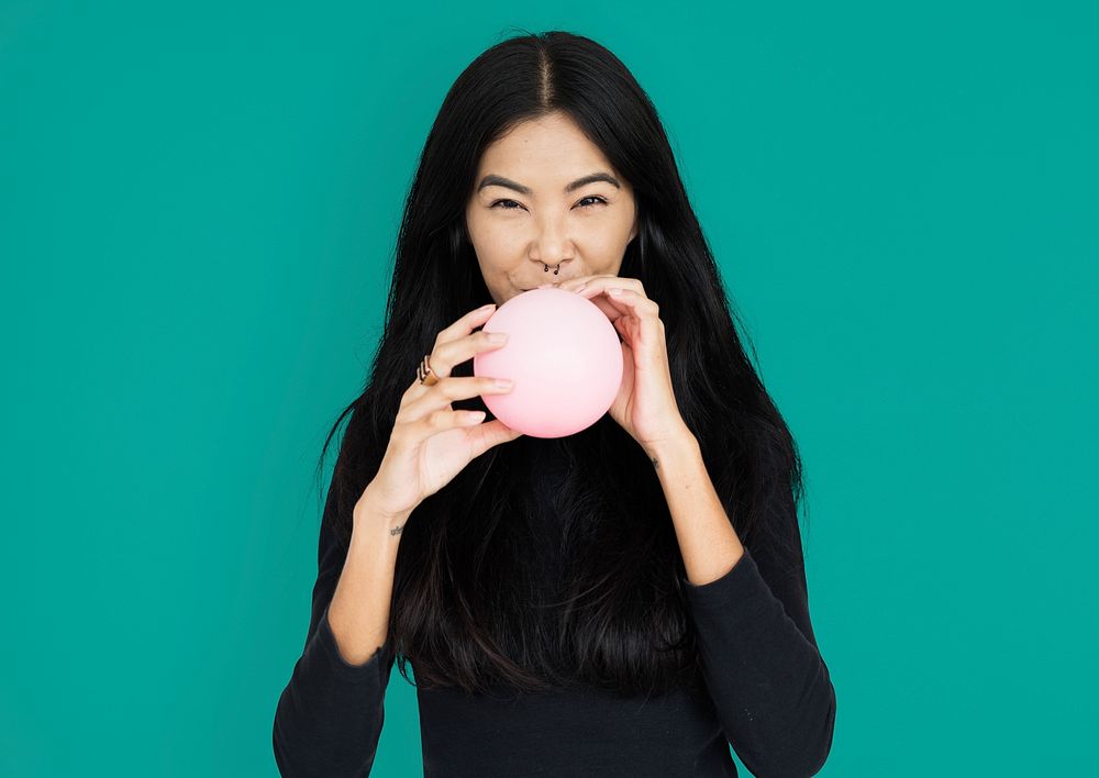Young asian woman casual blowing a balloon