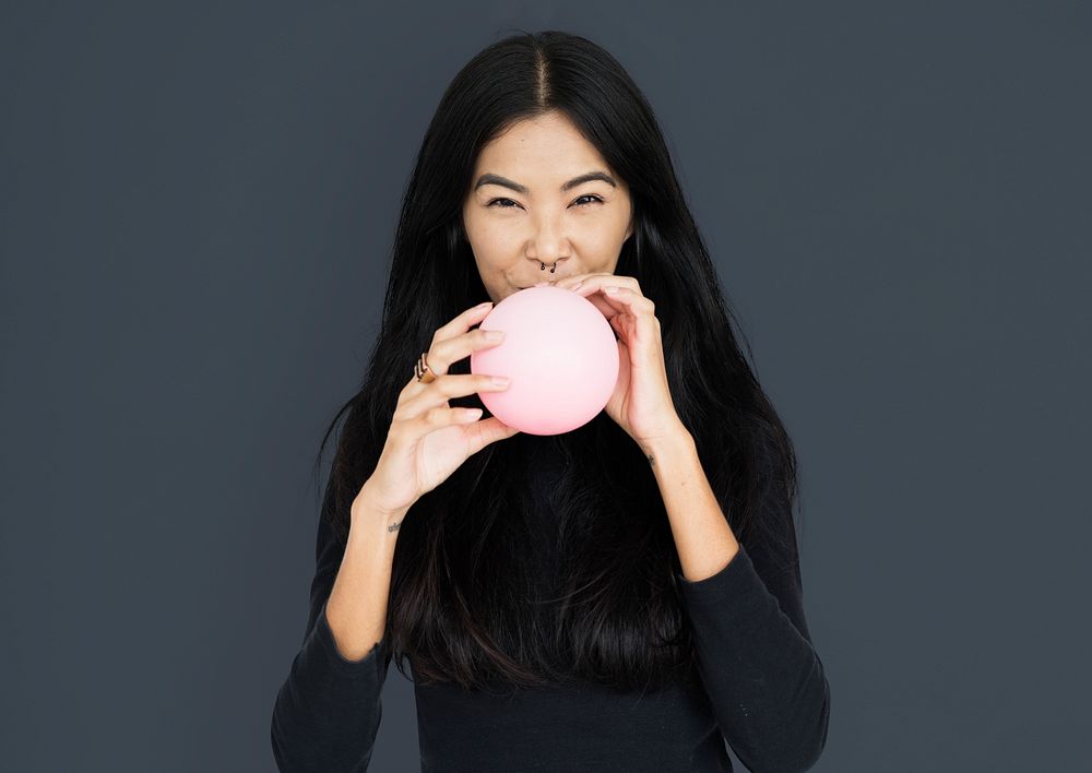 Young asian woman casual blowing a balloon