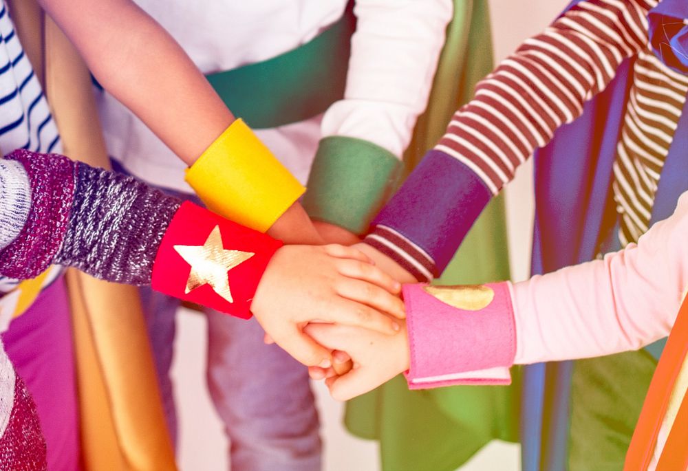 Superheroes kids hand stack together for support