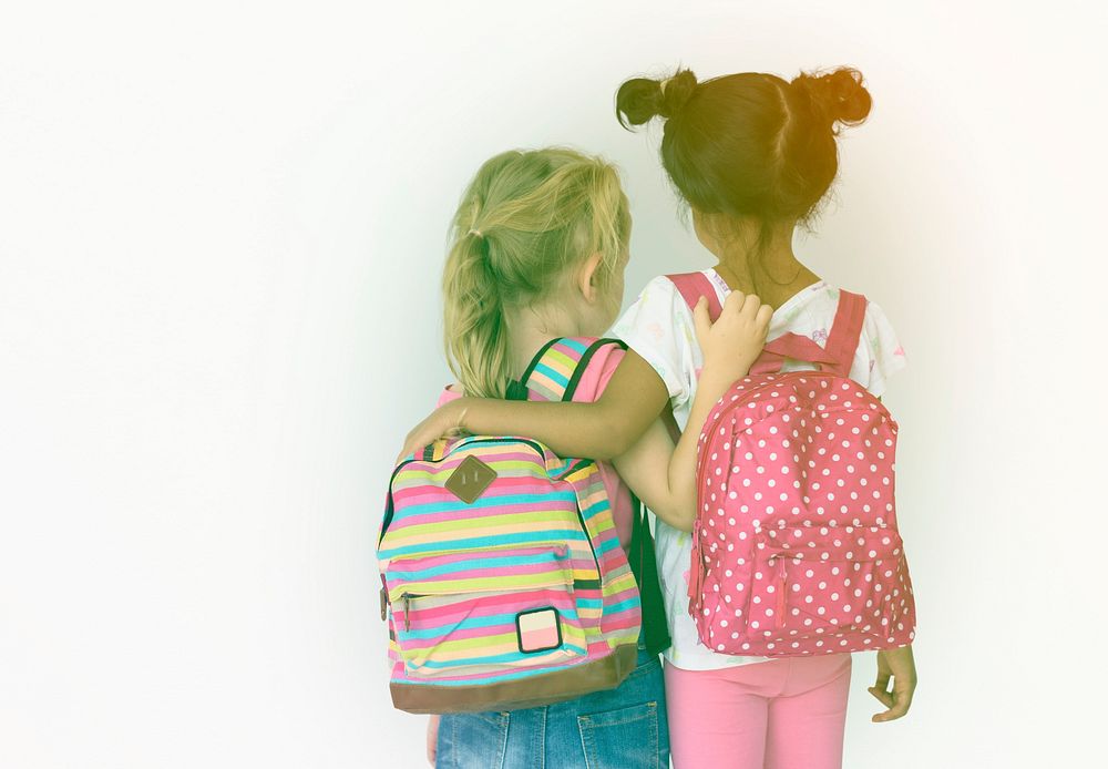 LIttle girls friends rear view with bag to go to school