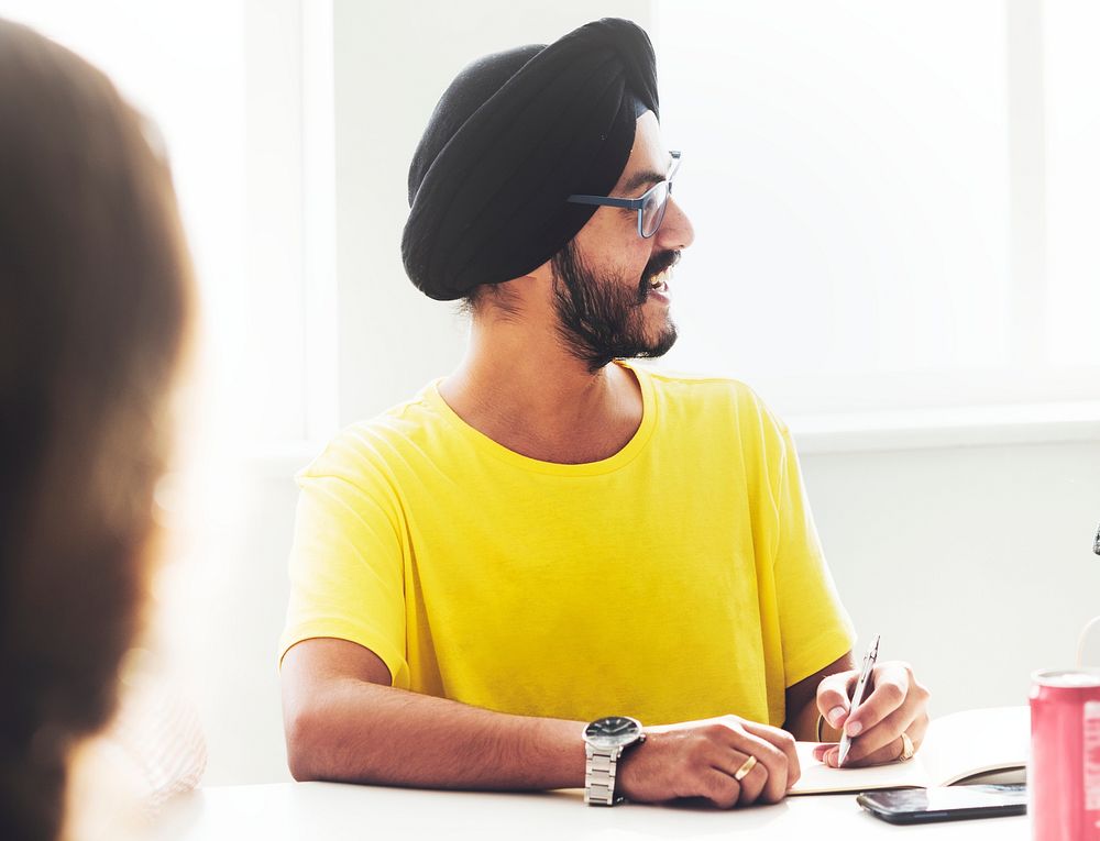 Guy wearing a turban in a meeting