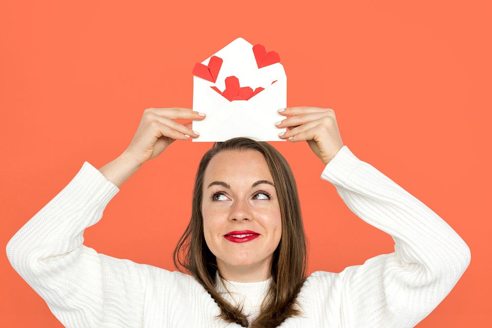Woman holding envelope red paper hearts