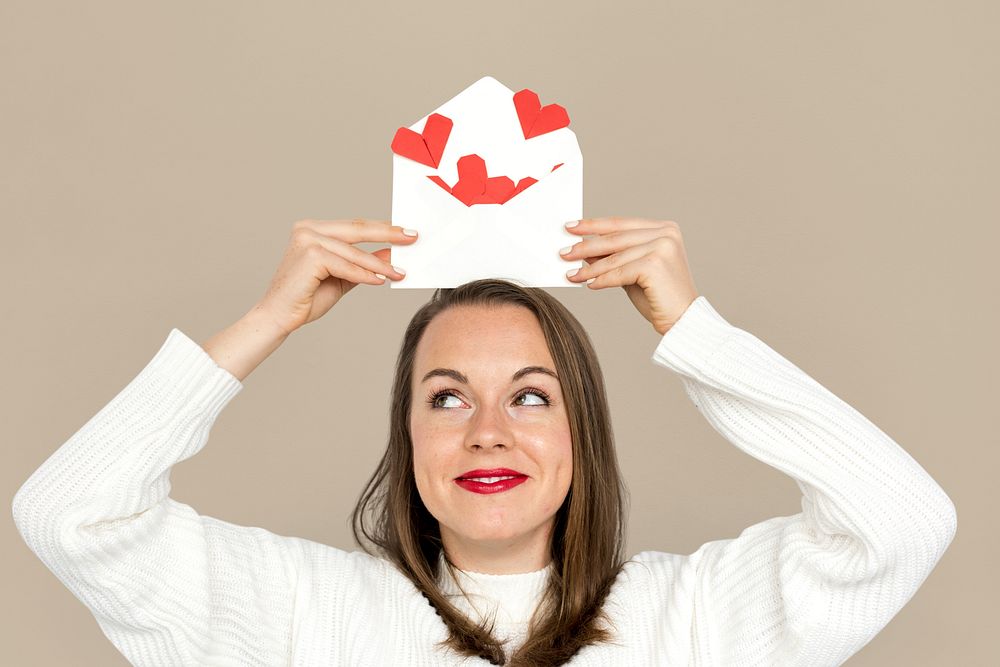 Woman holding envelope red paper hearts