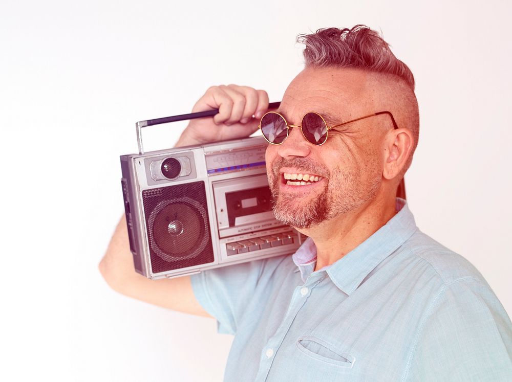 Senior man holding stereo media on white background