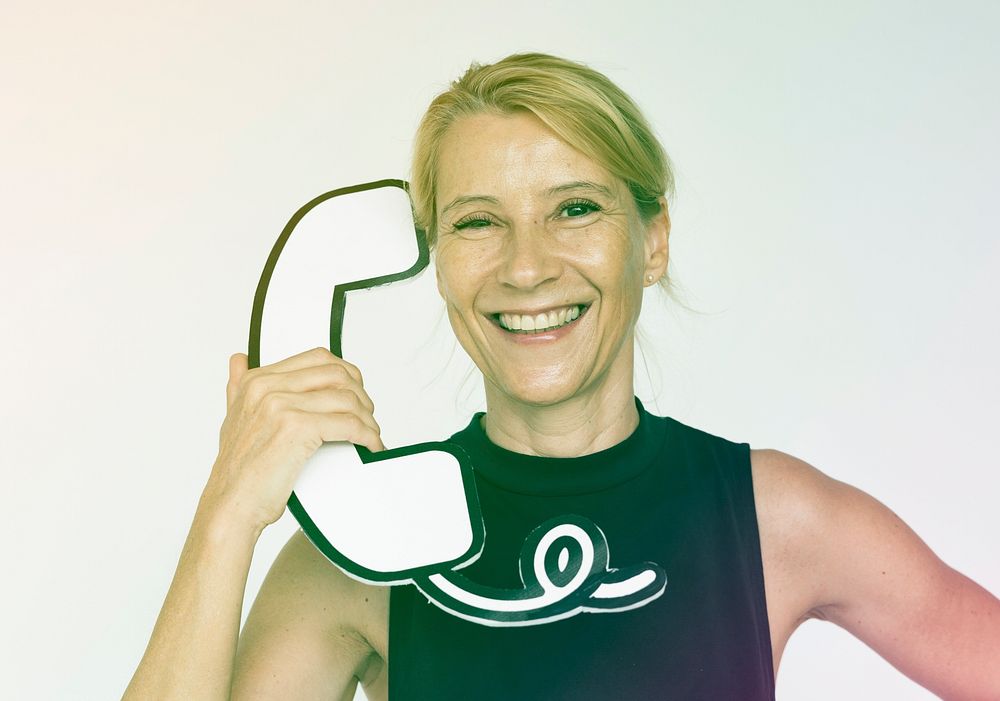 Woman holding papercraft telephone and smiling