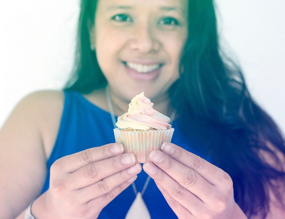 Woman smiling and holding cupcake dessert