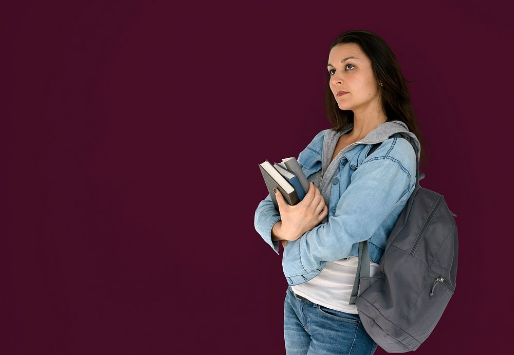 Girl student is carrying books and backpack