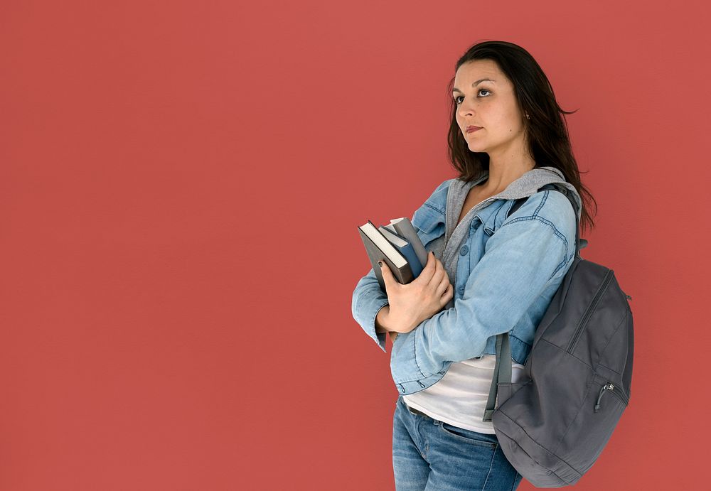 Girl student is carrying books and backpack